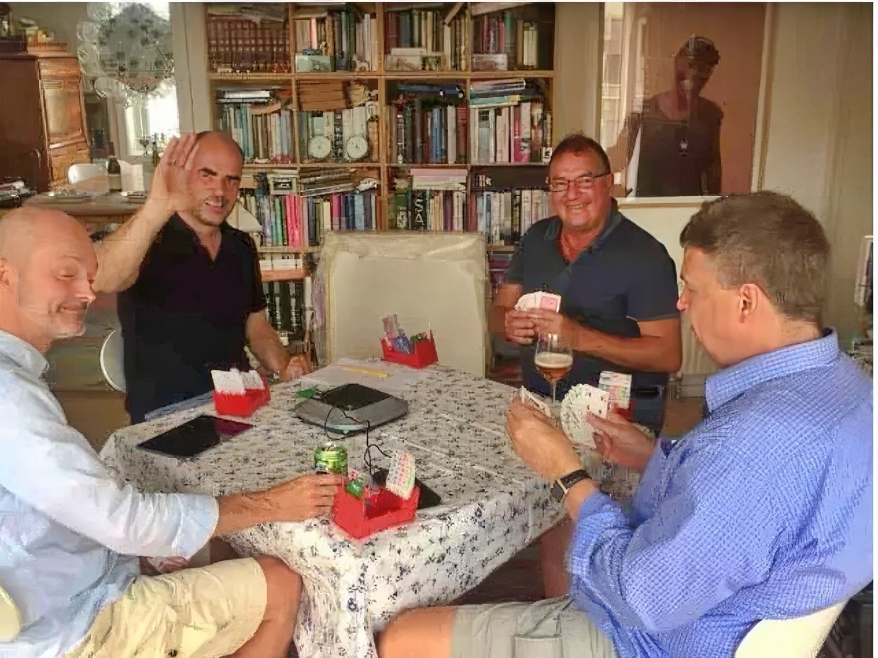 A stylish group of women playing cards at home.
